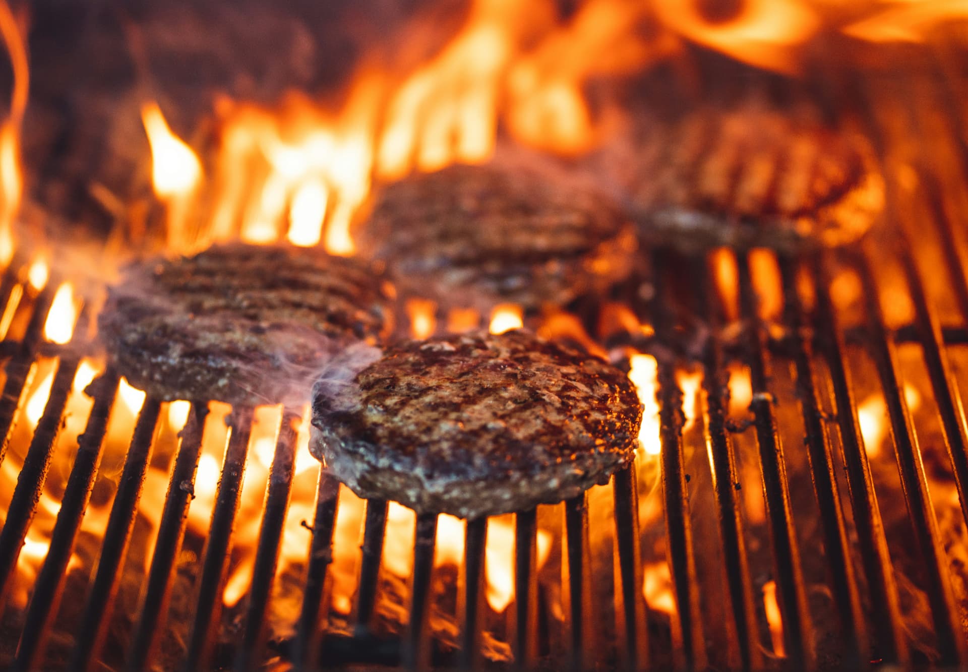 Burgere på flammende grill